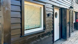 Un edificio de madera con una ventana y una puerta.