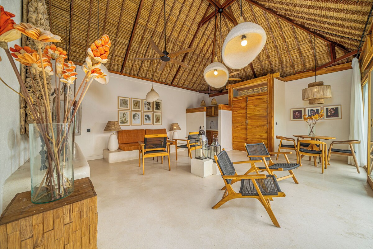 Un'ampia stanza con arredi in legno, una ventola a soffitto e una grande finestra.