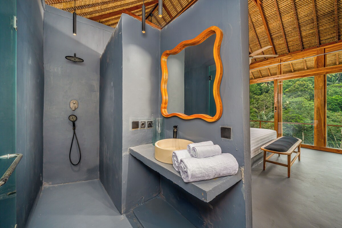 A modern bathroom with a shower, sink, and large mirror.
