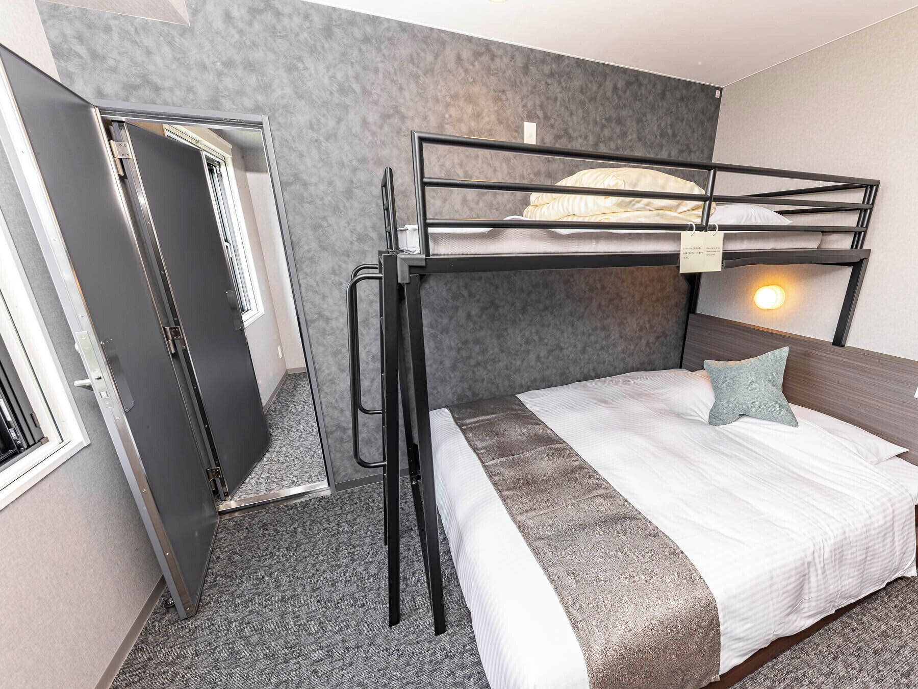 Ein Stockbett mit Kopfseitenverkleidung, ein Nachttisch und eine Wandleuchte.