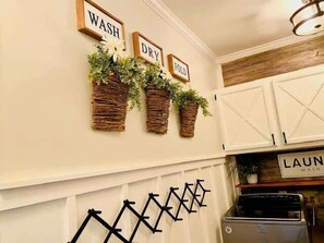 A kitchen with wooden cabinets, a stove, and three wall-mounted planters with greenery. - Sleep Eat Beach Repeat, Spacious Poolside Retreat (Conway)
