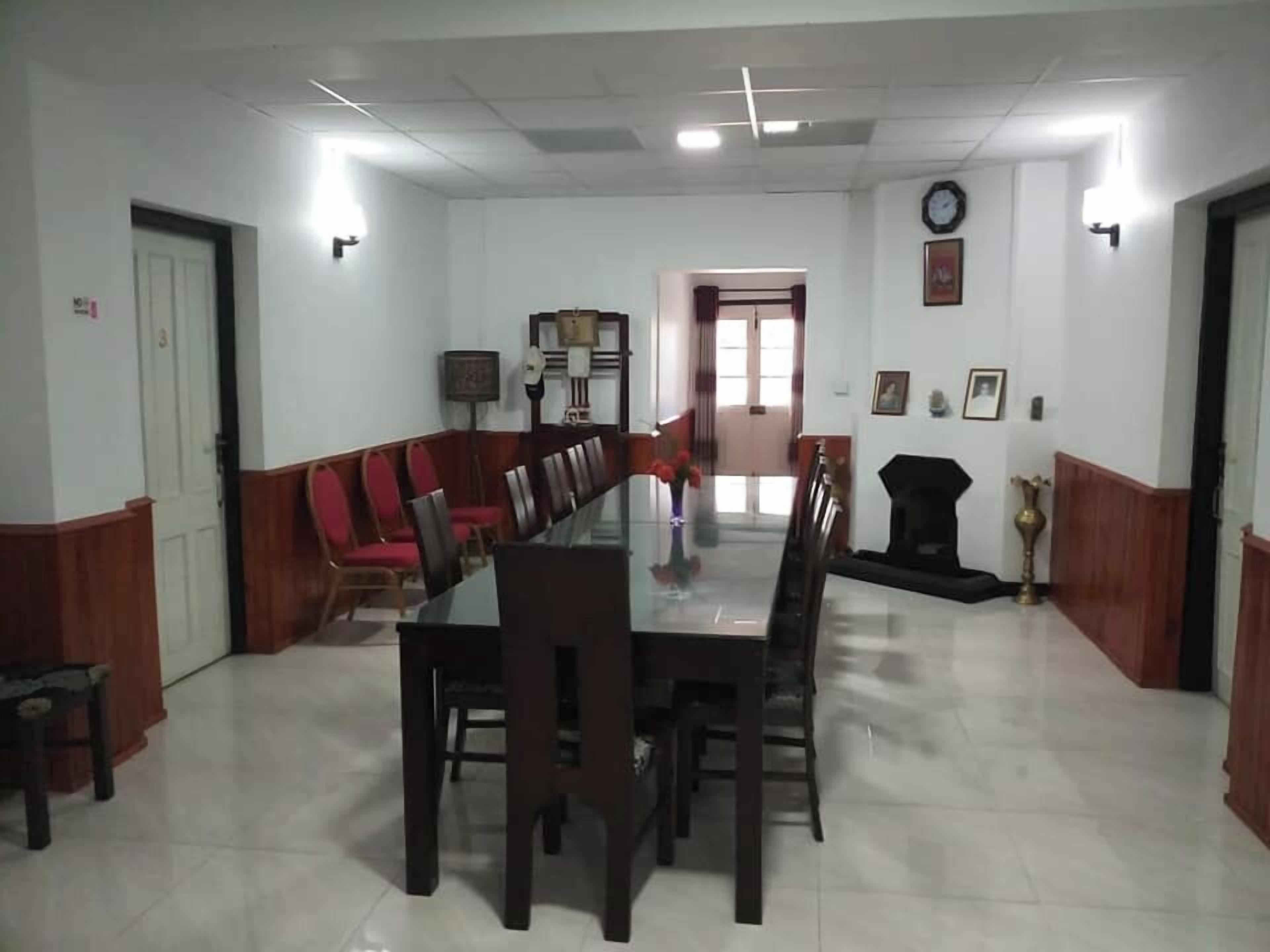Un salón de conferencias con una larga mesa y sillas, un sofá y una chimenea.