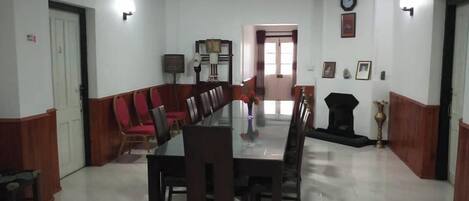 Un salón de conferencias con una larga mesa y sillas, un sofá y una chimenea.