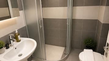 Buồng tắm vòi sen, khăn tắm, xà phòng, dầu gội