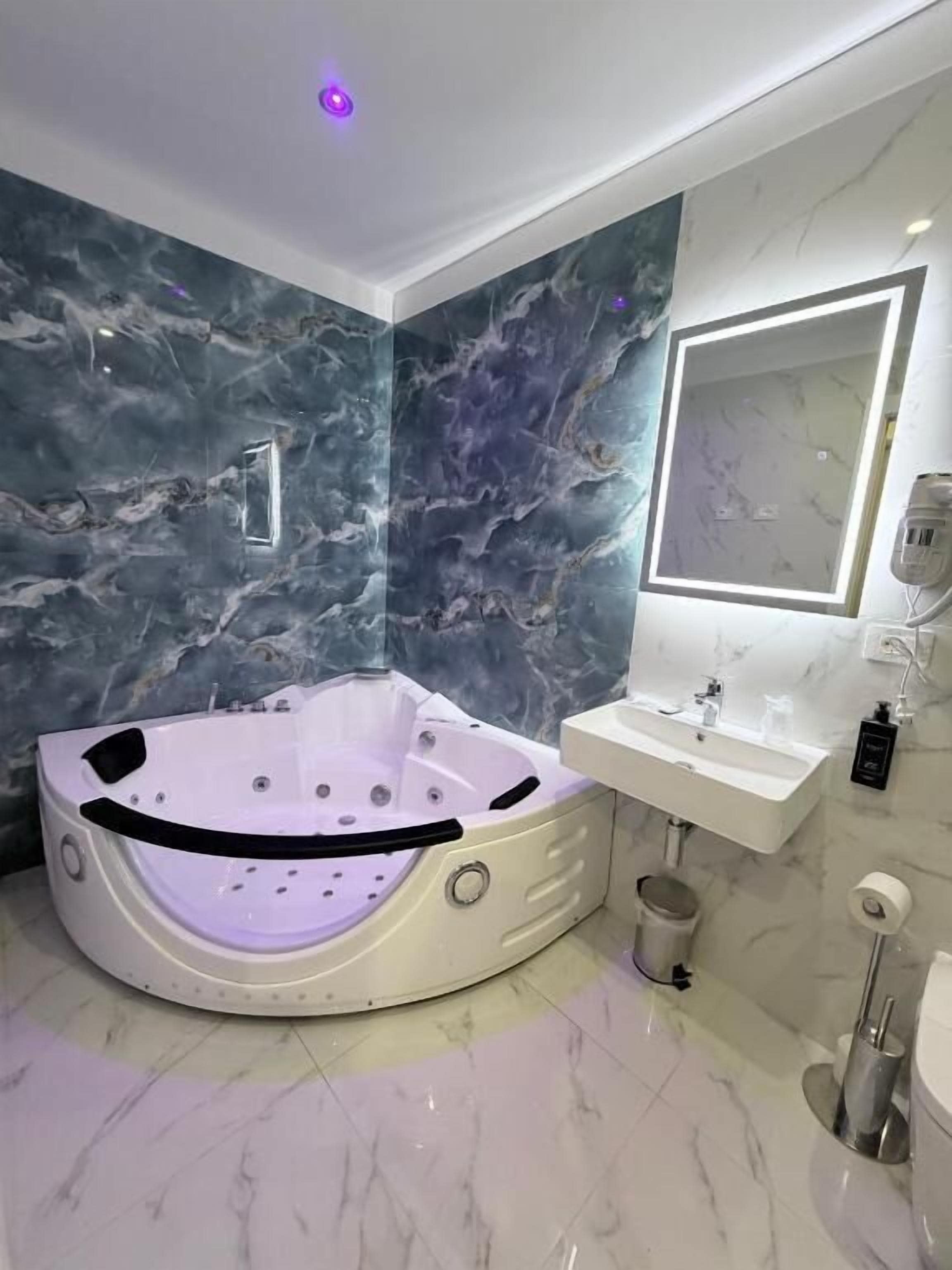 Luxe suite | Badkamer | Een haardroger, handdoeken, zeep, shampoo