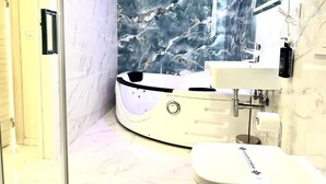Un baño moderno con un jacuzzi, un lavamanos y un inodoro.