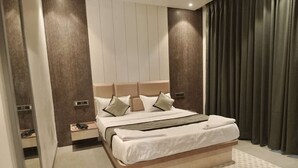 Quarto moderno com uma cama grande, uma mesinha de cabeceira e um espelho.