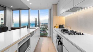 Een moderne keuken met een groot raam, een gasfornuis en uitzicht op de stad.