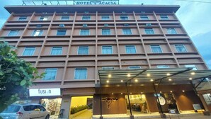 Et hotel med flere etager, en moderne facade, en overdækket indgang og et tydeligt skilt for virksomheden "fusion" i stueetagen.