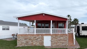 Il s’agit d’un bâtiment d’un seul étage, doté d’un toit rouge et d’une façade blanche, avec un petit porche orné d’une balustrade blanche et reposant sur des fondations en pierre.