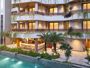 A multi-story hotel with a pool, outdoor bar, and lush greenery. - Bagaincha Resort & Spa (Pokhara)