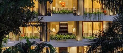 A multi-story building with balconies, a staircase, and indoor lighting.