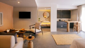 Une chambre d’hôtel moderne dotée d’un espace de vie, d’une cuisine et d’un coin repas.