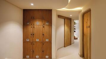 Een hal met houten lockers, een gebogen plafond en een deur met de tekst 'GODAVARI'.