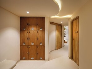 A hallway with wooden lockers, a curved ceiling, and a door labeled 'GODAVARI'. - Bagaincha Resort & Spa (Pokhara)
