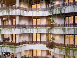 A multi-story hotel with balconies, indoor seating areas, and plants. - Bagaincha Resort & Spa (Pokhara)