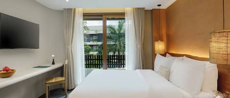 A hotel room with a bed, a desk, a TV, a lamp, and a view of the outdoors.