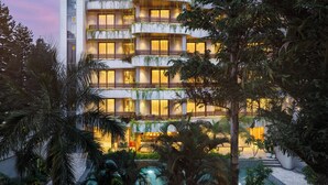 A multi-story hotel with balconies, a pool, and lush greenery. - Bagaincha Resort & Spa (Pokhara)