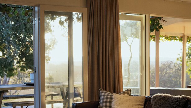 Una sala de estar moderna con un sofá de cuero, una mesa de centro y vistas a un patio.
