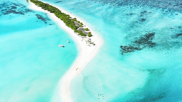 An aerial view of a tropical island with clear turquoise waters, white sandy beaches, and lush greenery. - ARIA Beach Ukulhas (Ukulhas)