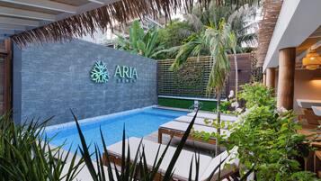 Een buitenzwembad, ligstoelen bij het zwembad