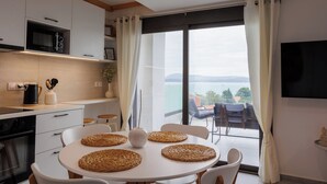 Eine moderne Küche mit Mikrowelle, Kaffeemaschine und einem Essbereich mit rundem Tisch und Stühlen.