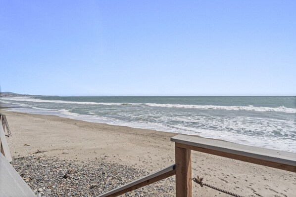 A beach with a wooden railing and a rocky foreground. - Oceanfront 3BR w/ beach stairs & BBQ (Dana Point)