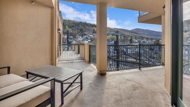 A balcony with a view of a town and mountains.