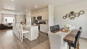 A modern apartment with a kitchen, dining area, and living room.