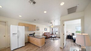 A spacious living area with a kitchen, a dining area, and a bedroom. - Relaxing Coastal Cottage Close to the Beach (Galveston)