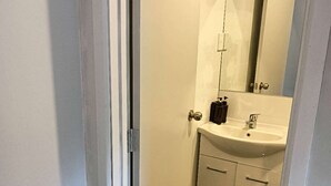 A bathroom with a sink, mirror, and cabinet. - 1 Bedroom garden chalet 7B  (Rotorua)