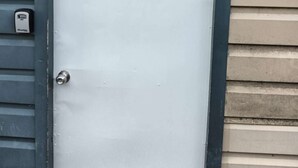 A white door with a 'B' marking, a doorbell, and a grey frame. - 1 Bedroom garden chalet 7B  (Rotorua)