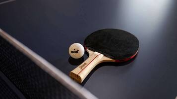 A table tennis table with a paddle and a ball.