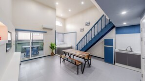 Eine moderne Küche mit Essbereich, einer Treppe und Blick ins Freie.