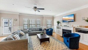 A living room with a sofa, armchair, coffee table, and fireplace. - Modern 3 Bedroom Condo in a Prime Location (Wildwood)