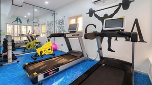 Ein Fitnessraum mit Laufbändern, Fahrrädern und Rudergeräten.