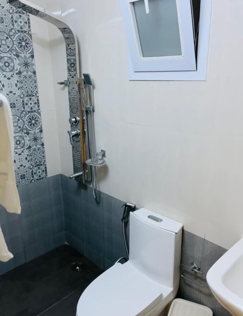 A bathroom with a shower, toilet, and sink.