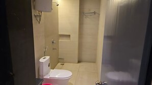 A small bathroom with a toilet, sink, and shower. - RAGHAV STAY INN (Faizabad)