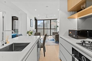 A modern kitchen with a central island, built-in appliances, and a dining area with a view.