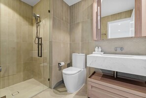 A modern bathroom with a glass shower enclosure, a toilet, and a marble sink. - 59th Floor Luxury | Skyline & River Views (Brisbane City)