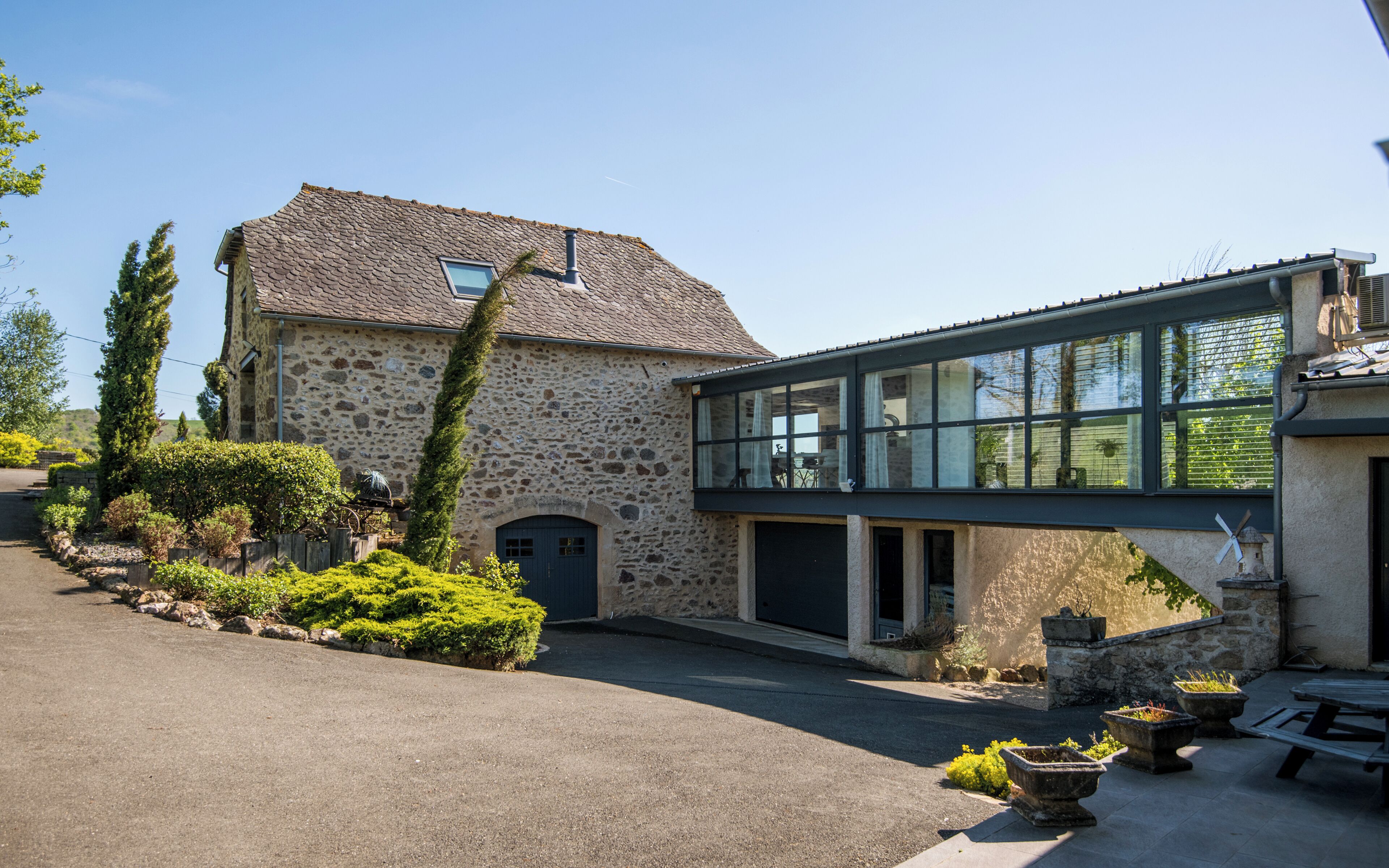 A stone house with a modern extension featuring large windows.