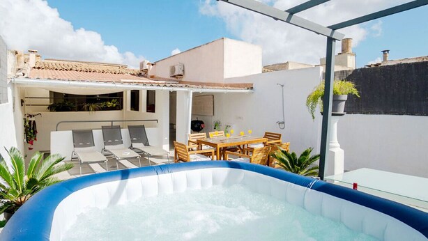 Une piscine extérieure avec un espace de repos équipé de chaises longues et une table à manger.