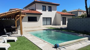 A modern house with a swimming pool, a patio with lounge chairs, and a pergola. - Villa chat l'heureuse (Villemolaque)