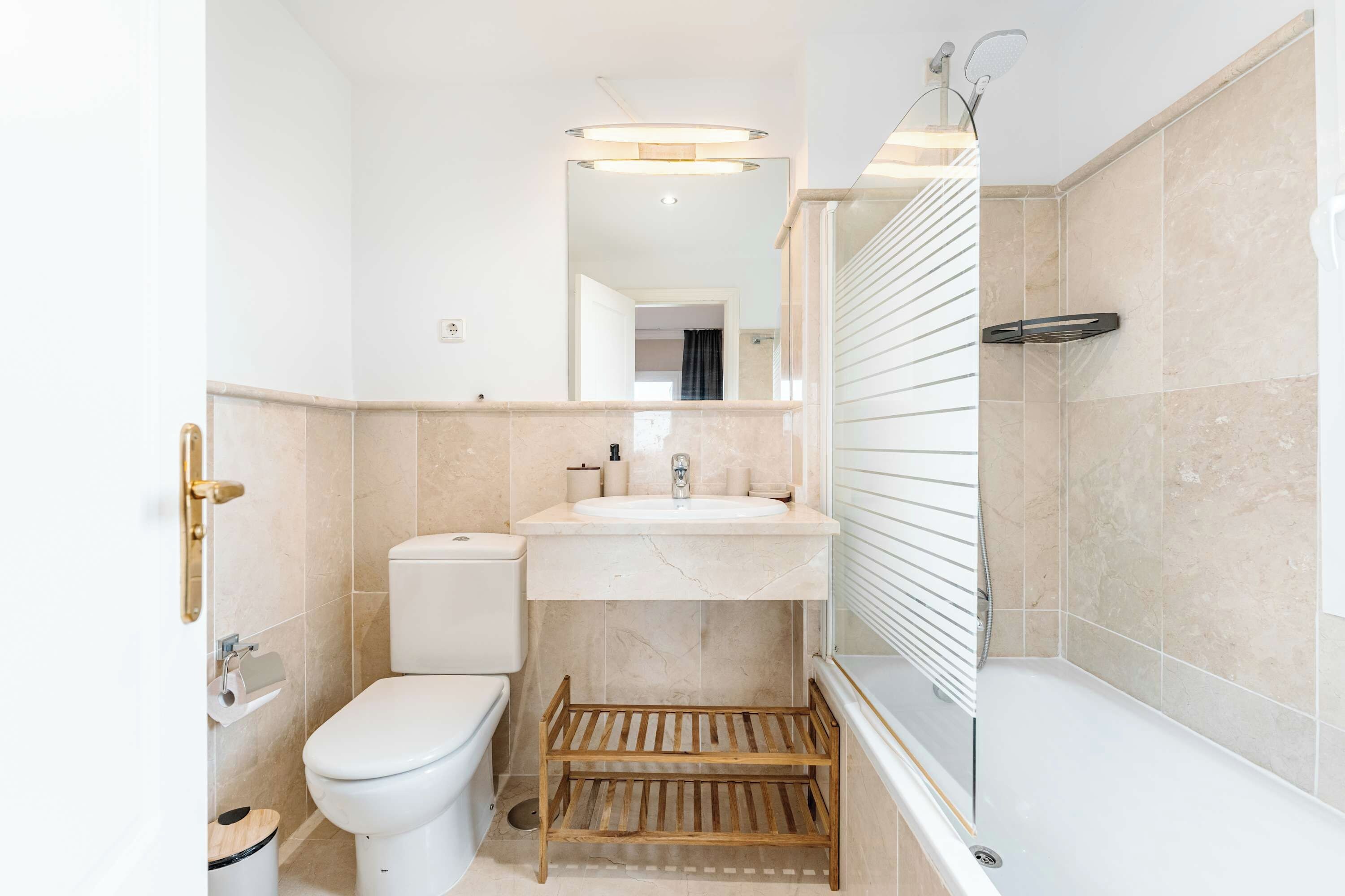 A modern bathroom with a toilet, sink, and shower.