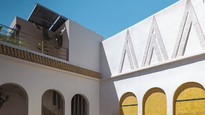 A courtyard with a pool, arched windows, and a staircase. - Riad Romeo (Marrakech)