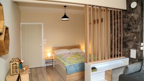 A bedroom with a bed, bedside table, lamp, and a built-in bench with storage. - Colibri Castle View – Romantic Escape (Veliko Tarnovo)