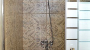 A shower with a handheld showerhead and a wall-mounted faucet. - Colibri Castle View – Romantic Escape (Veliko Tarnovo)