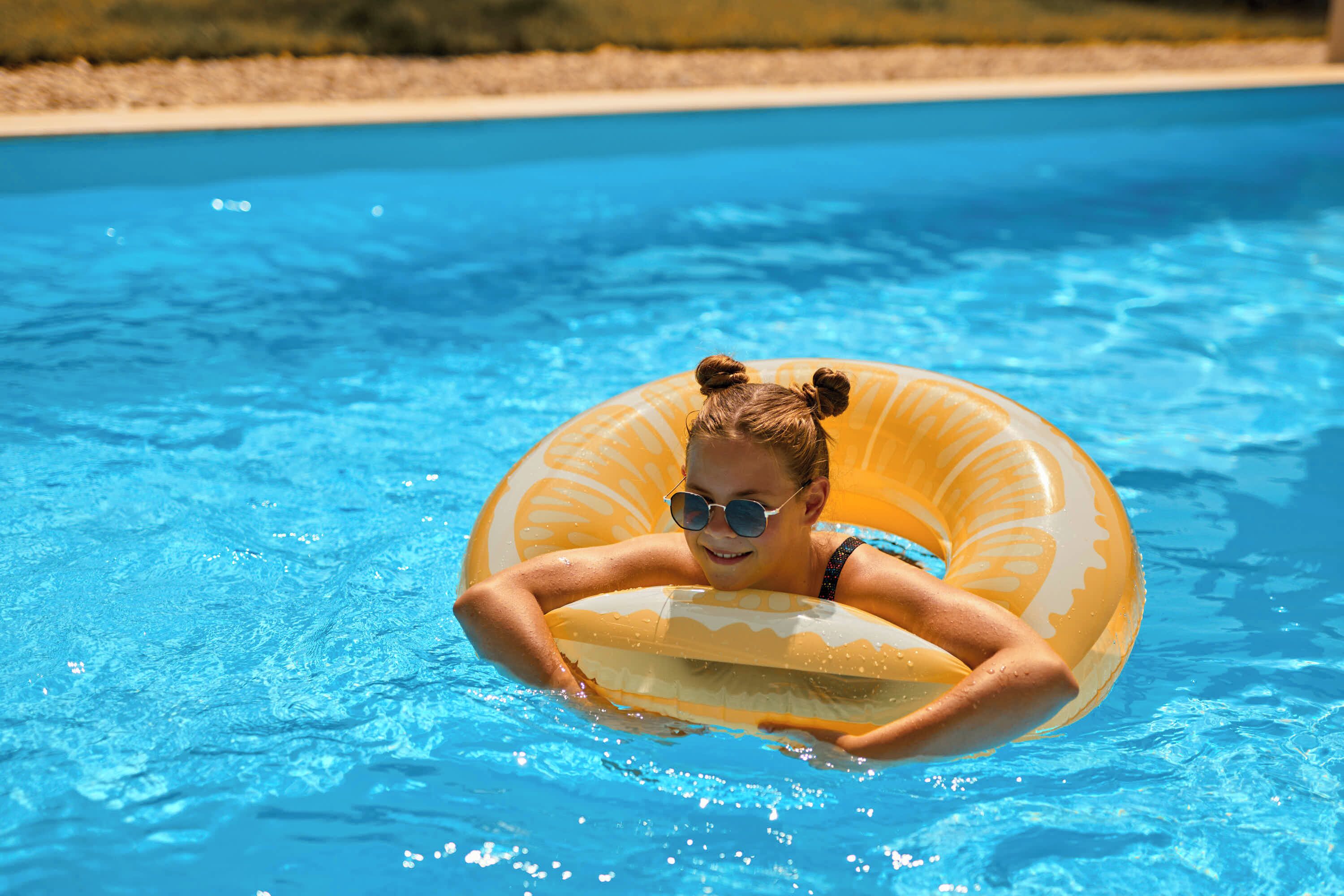 Eine Person im Schwimmbecken mit einem gelben Schwimmreifen.