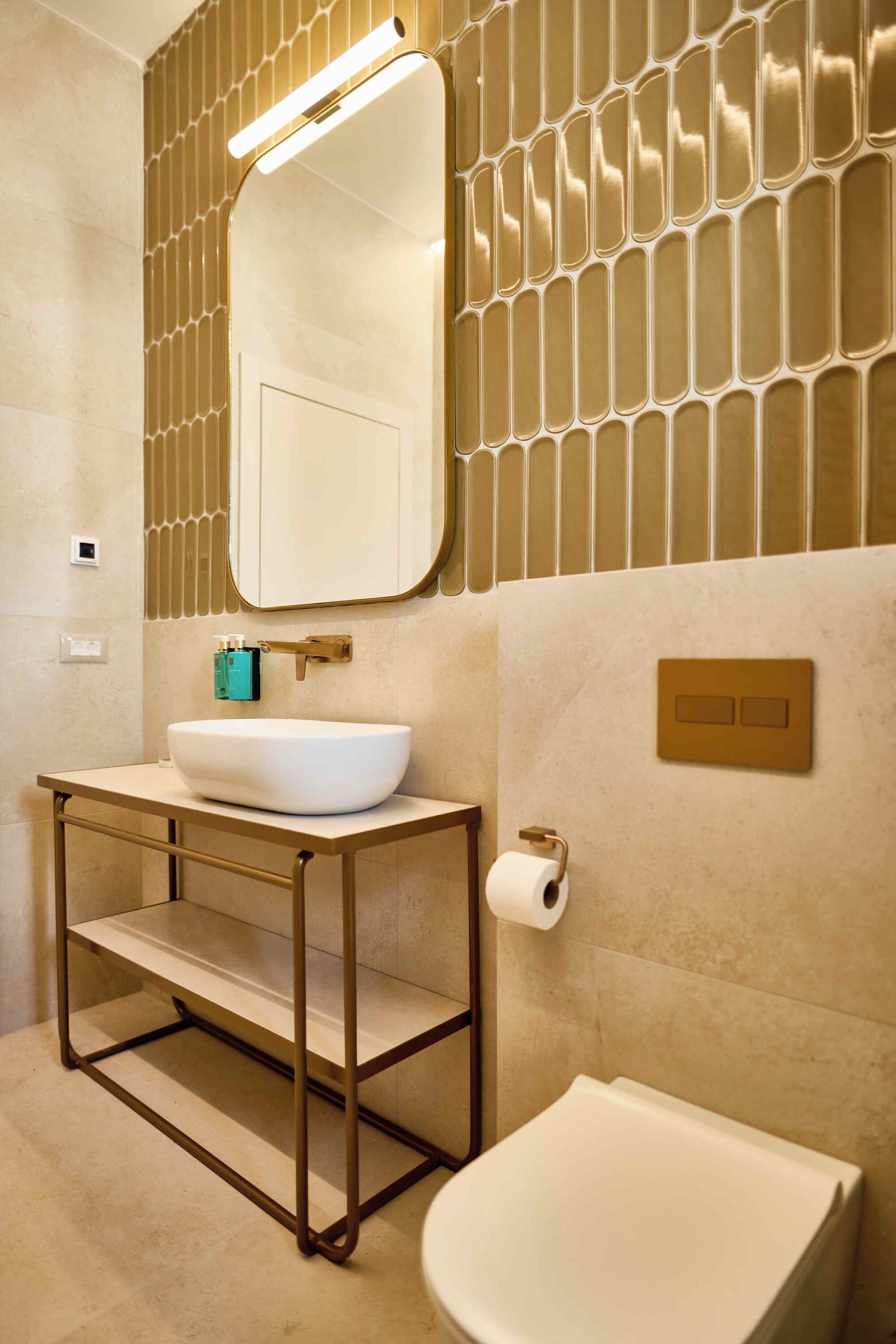 Een badkamer met een wit wastafel, een spiegel, een toilet en een handdoekhouder.
