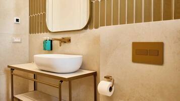 Een badkamer met een wit wastafel, een spiegel, een toilet en een handdoekhouder.
